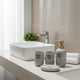 Elegant 4-piece ceramic bathroom accessory set with soap dispenser, toothbrush holder, tumbler, and vanity tray for modern bathroom organization.
