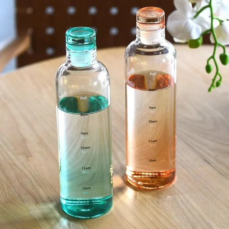 Reusable glass drinking bottle with time tracking scale for water, juice, iced coffee, smoothies, and cold beverages.